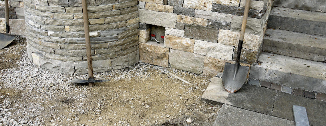 Brunnen in Natursteinmauer integriert